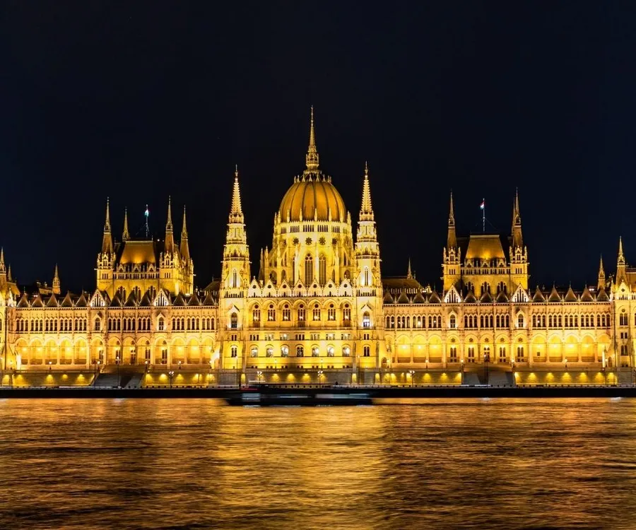 The Hungarian Parliament building illuminated at night on the Danube River in Budapest